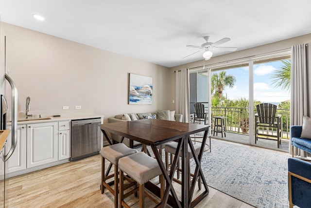 dining space featuring light hardwood / wood-style flooring, ceiling fan, and sink