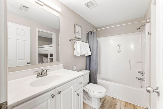 bathroom featuring toilet, visible vents, wood finished floors, and vanity