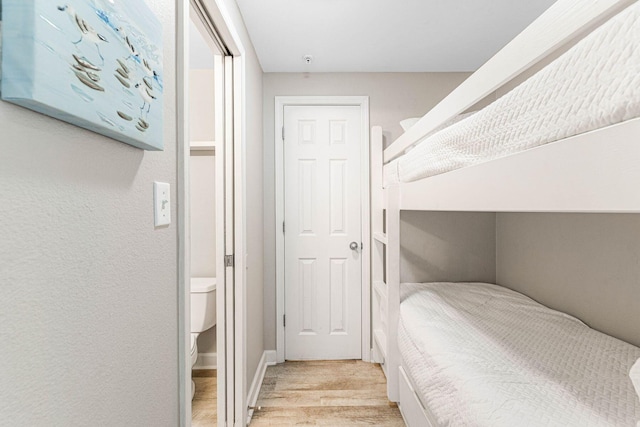 bedroom with baseboards and wood finished floors