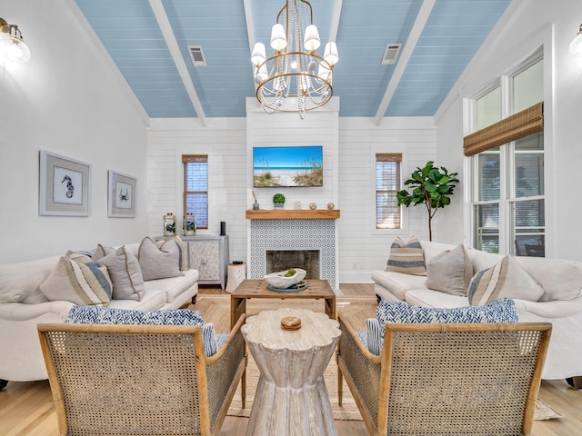 living room with beamed ceiling, light hardwood / wood-style floors, and plenty of natural light