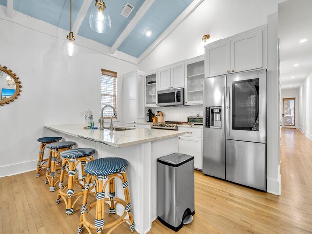 147 Silver Laurel Way, Santa Rosa Beach, FL 32459 - kitchen with a breakfast bar area, visible vents, appliances with stainless steel finishes, beamed ceiling, and light wood-style floors