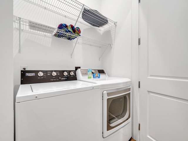 clothes washing area with separate washer and dryer