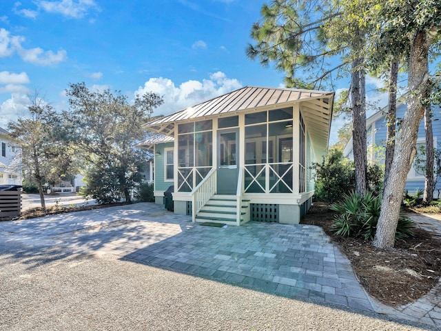 view of front of house featuring a sunroom and a patio area