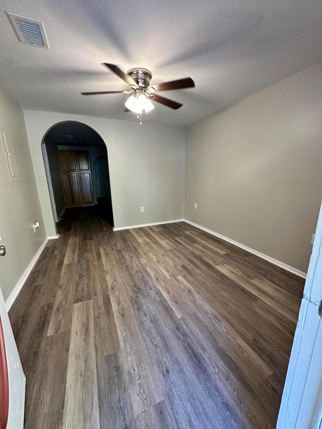 empty room with ceiling fan and dark hardwood / wood-style flooring