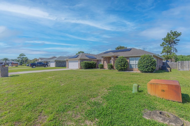 ranch-style house with a front lawn, solar panels, and a garage