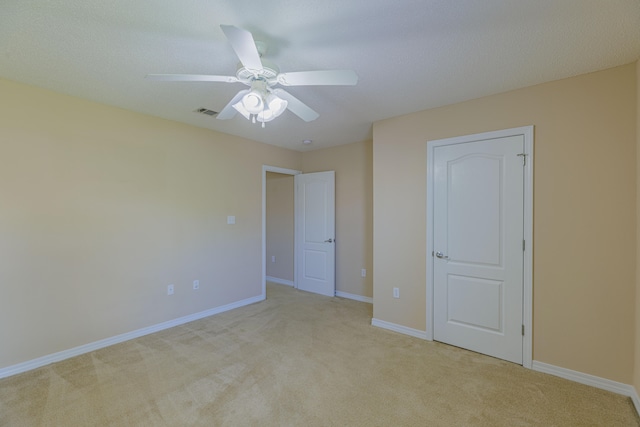 unfurnished bedroom with light carpet and ceiling fan