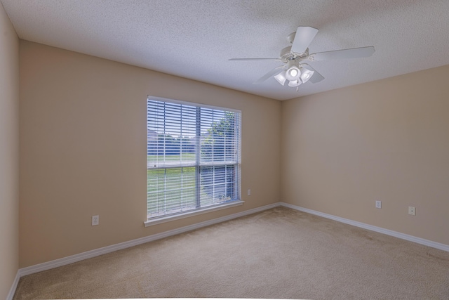 unfurnished room featuring light carpet, ceiling fan, and a textured ceiling