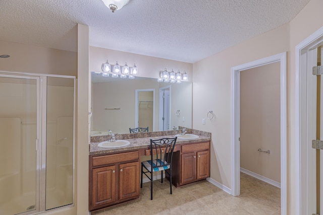 bathroom featuring a textured ceiling, walk in shower, and vanity