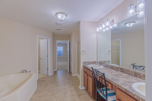 bathroom with a textured ceiling, vanity, and plus walk in shower