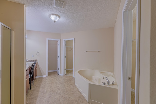 bathroom featuring independent shower and bath, vanity, a textured ceiling, and tile patterned floors