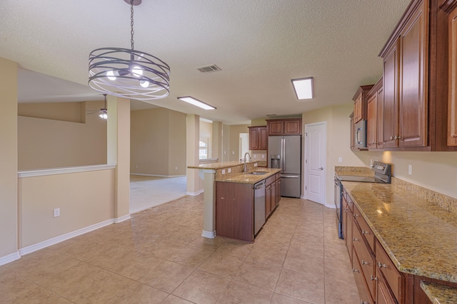 kitchen featuring stainless steel appliances, an inviting chandelier, decorative light fixtures, a center island with sink, and sink