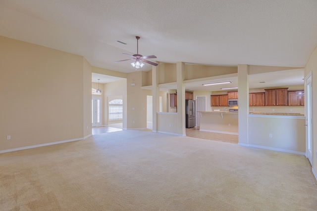 unfurnished living room featuring high vaulted ceiling, a textured ceiling, light colored carpet, and ceiling fan with notable chandelier