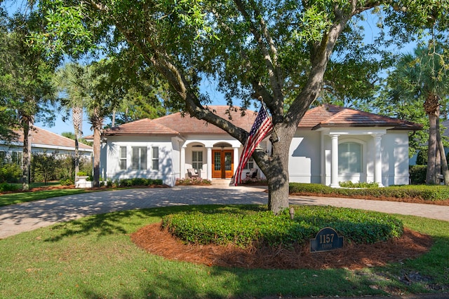 mediterranean / spanish house featuring a front yard and french doors