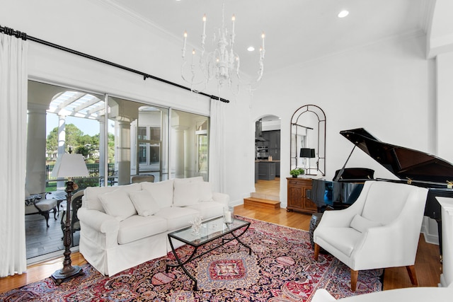 living room featuring ornamental molding, a chandelier, and light hardwood / wood-style floors