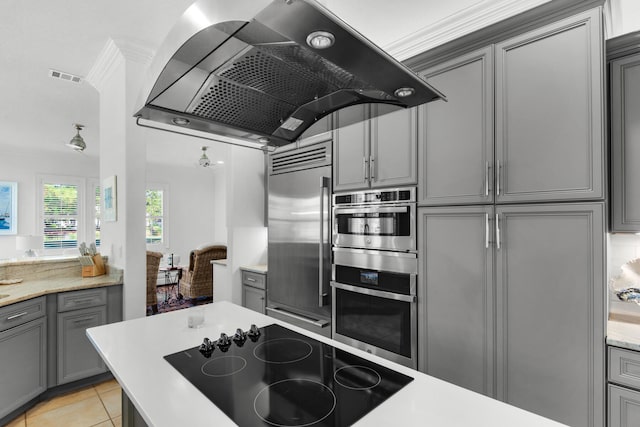 kitchen with light tile patterned flooring, ornamental molding, built in refrigerator, extractor fan, and black electric stovetop