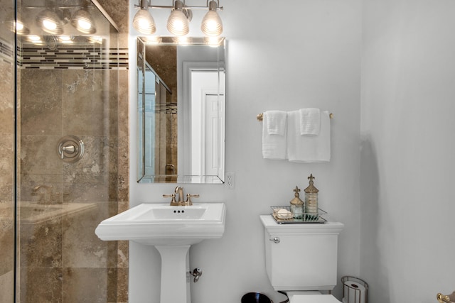 bathroom featuring a shower with shower door and toilet