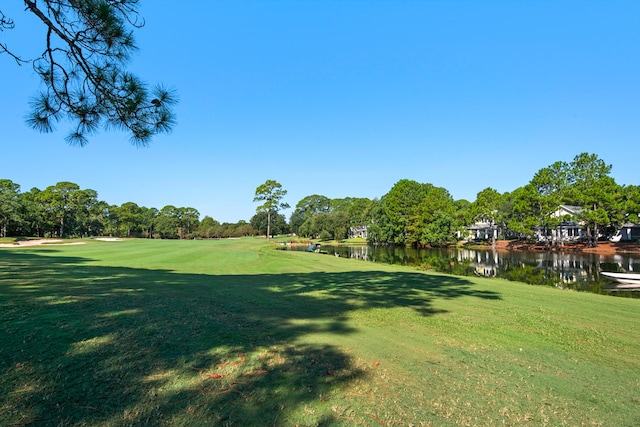 view of home's community featuring a lawn and a water view