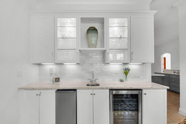 bar with white cabinets, light tile patterned flooring, beverage cooler, light stone countertops, and decorative backsplash