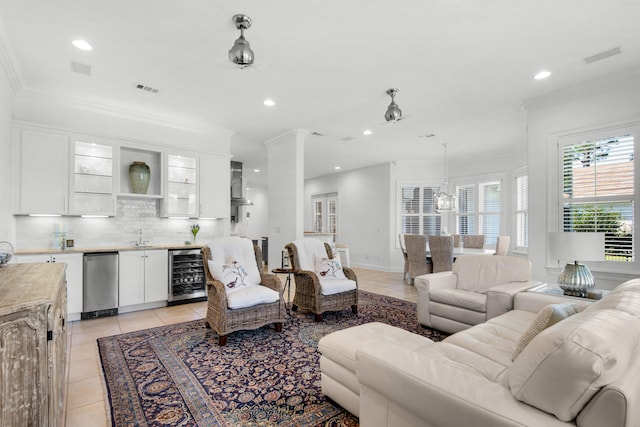 living room with indoor wet bar, wine cooler, ornamental molding, and light tile patterned flooring