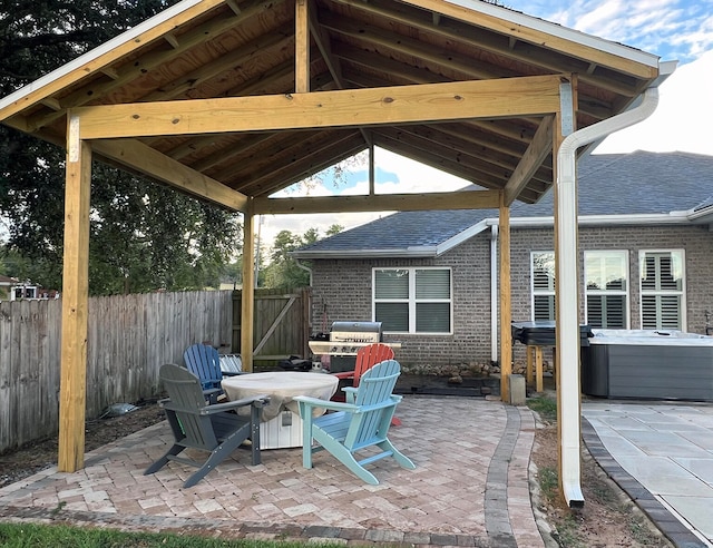 view of patio / terrace featuring a gazebo, a hot tub, and a grill