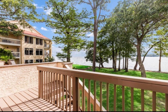 wooden deck with a yard and a water view