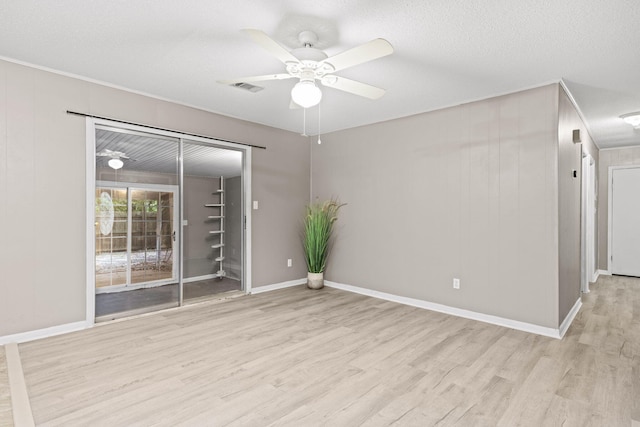 spare room featuring light hardwood / wood-style flooring, ceiling fan, and a textured ceiling