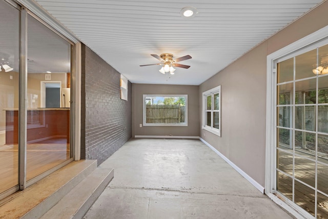 unfurnished sunroom with ceiling fan