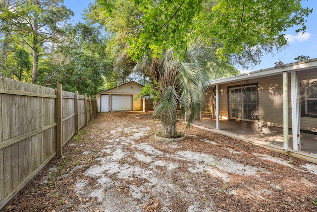 view of yard with a garage and an outbuilding