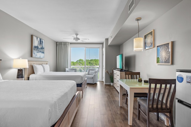 bedroom featuring ceiling fan, white refrigerator, dark hardwood / wood-style flooring, and access to outside