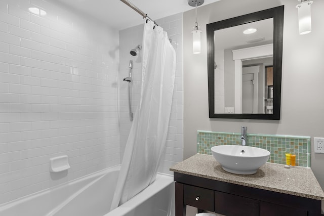 bathroom featuring shower / bath combo with shower curtain, backsplash, and vanity