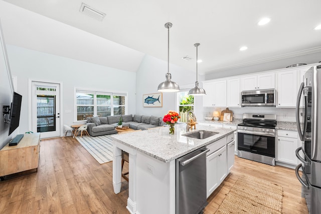 kitchen featuring stainless steel appliances, white cabinetry, a kitchen island with sink, and sink