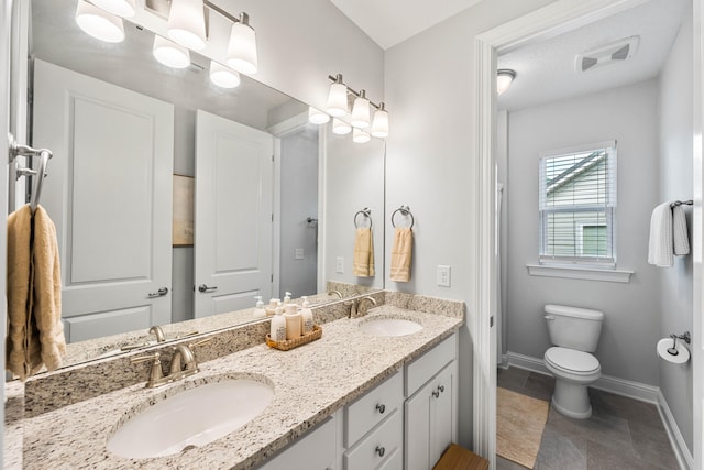 bathroom with vanity, tile patterned flooring, and toilet