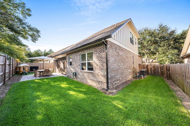 rear view of property featuring a patio, central AC, and a yard