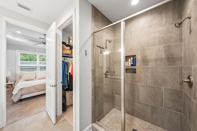 bathroom featuring tile patterned flooring, ceiling fan, and an enclosed shower