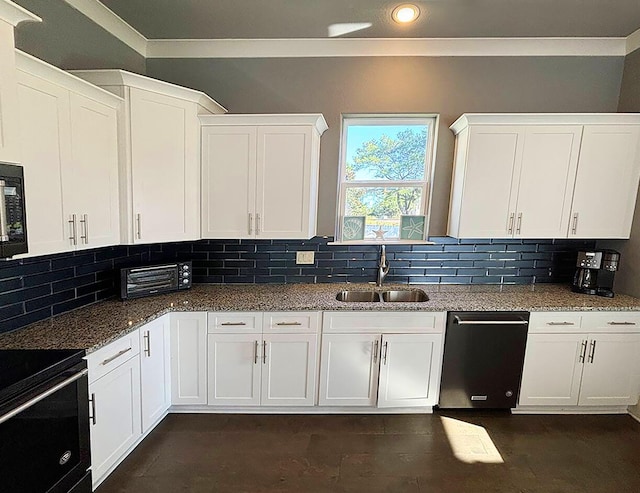 kitchen featuring dark stone countertops, white cabinetry, and sink