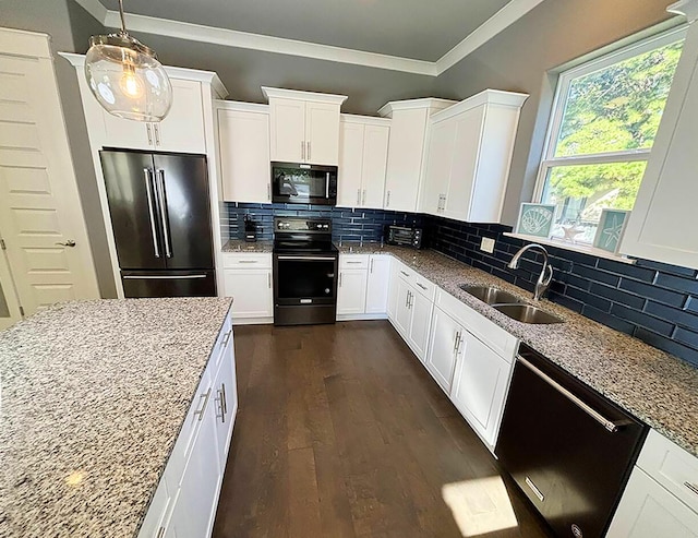 kitchen with light stone countertops, white cabinets, black appliances, and hanging light fixtures