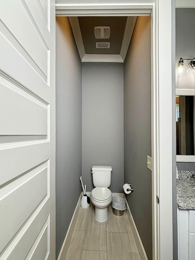 bathroom with vanity, toilet, and hardwood / wood-style flooring