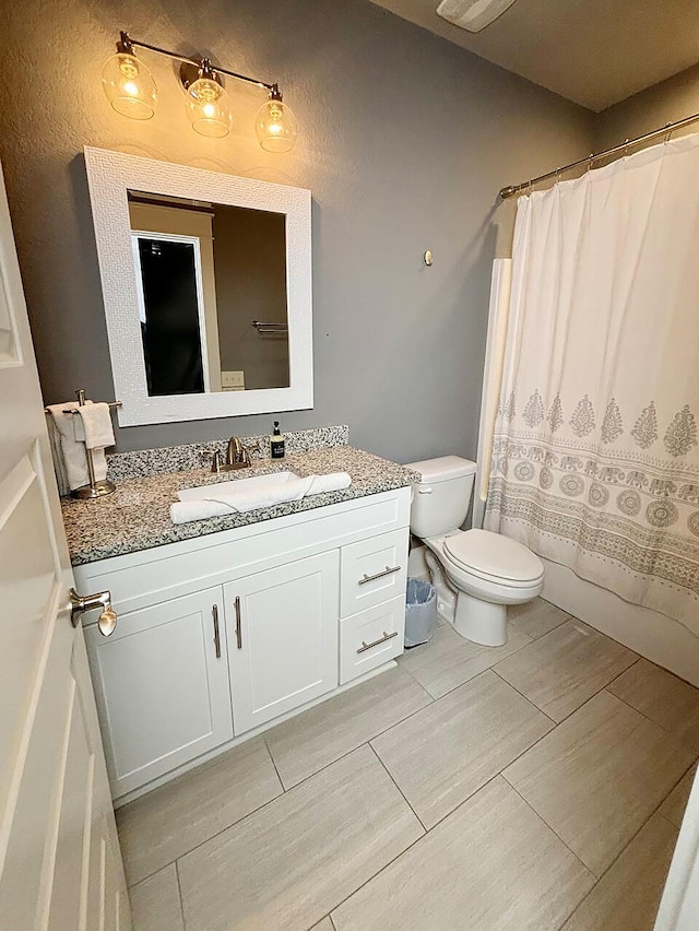 full bathroom with vanity, shower / tub combo, and toilet