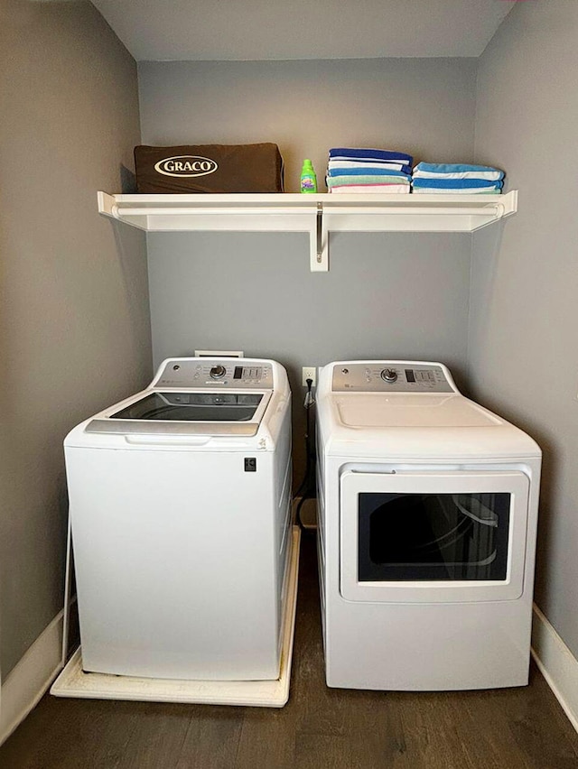 laundry area with dark hardwood / wood-style floors and independent washer and dryer