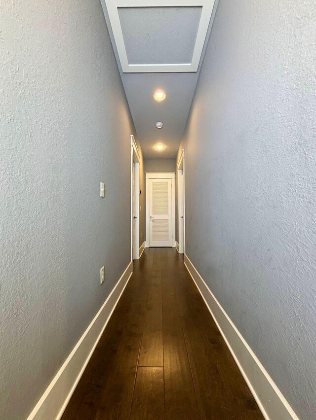 corridor with dark hardwood / wood-style flooring