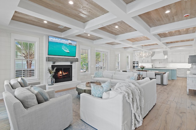 living room featuring wood ceiling, coffered ceiling, light wood-type flooring, beam ceiling, and a chandelier