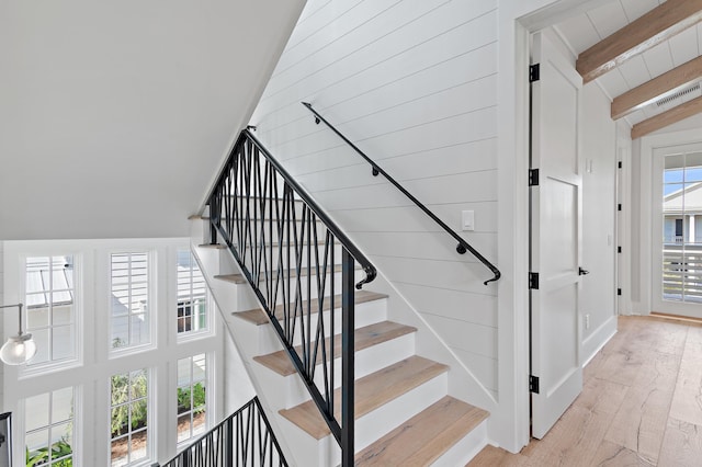 staircase with vaulted ceiling with beams and hardwood / wood-style flooring