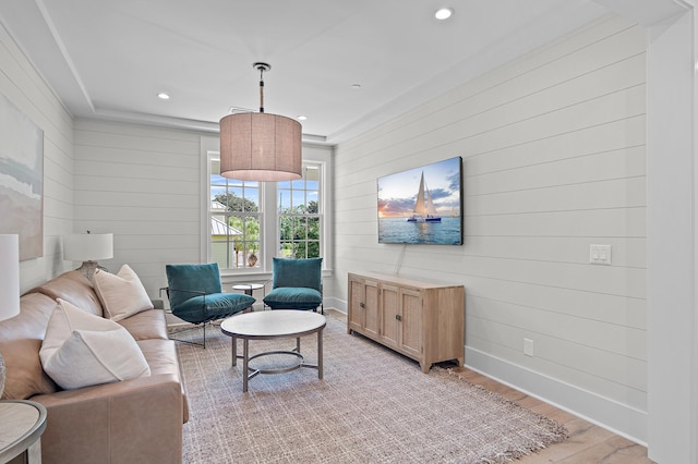 living room featuring light hardwood / wood-style flooring and wood walls