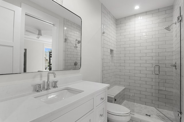 bathroom with walk in shower, vanity, and toilet