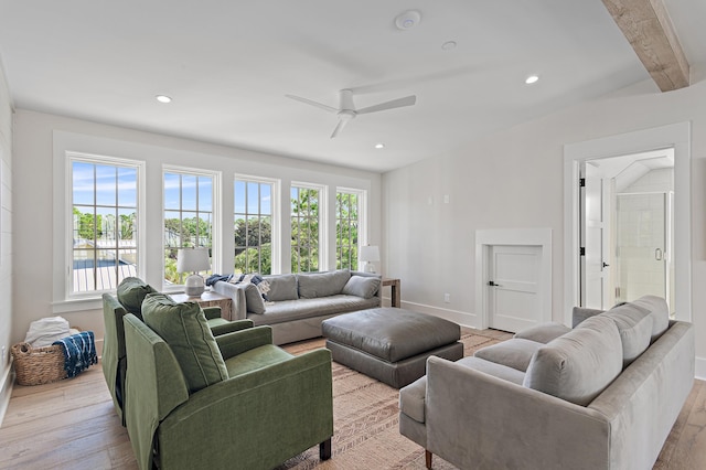 living room with ceiling fan, light wood-type flooring, and beam ceiling