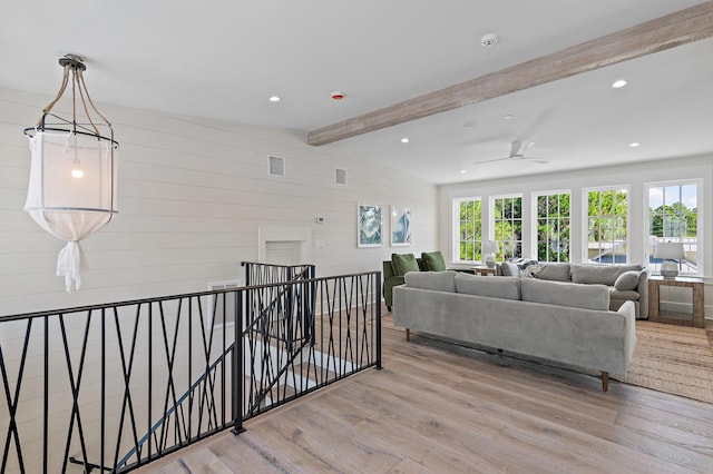 living room featuring light hardwood / wood-style flooring, vaulted ceiling with beams, and wood walls