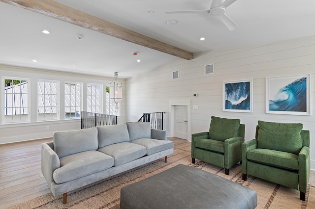 living room featuring light wood-type flooring, vaulted ceiling with beams, wood walls, and ceiling fan