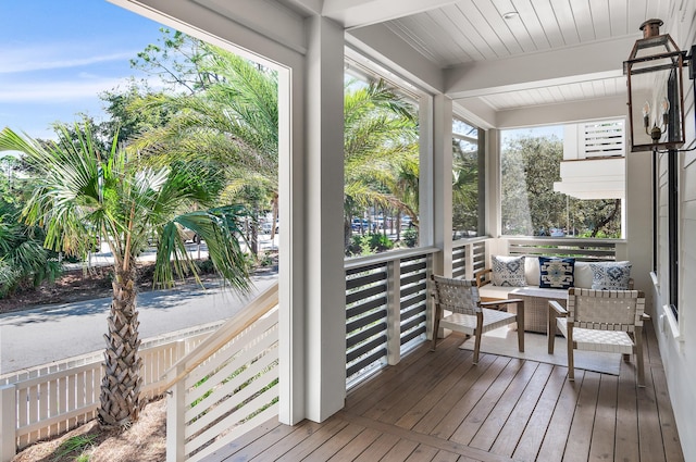 sunroom / solarium featuring beamed ceiling