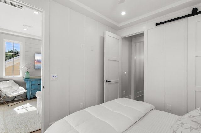 bedroom featuring a barn door and carpet flooring