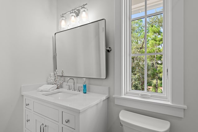 bathroom with plenty of natural light, vanity, and toilet